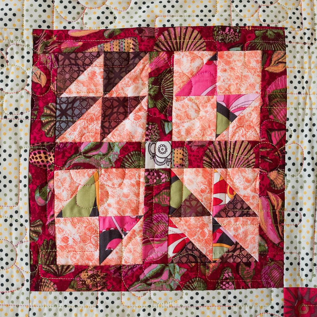 Quilt with colorful patchwork pattern on a textured background