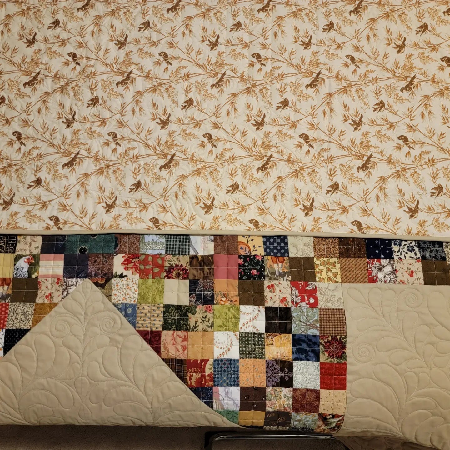 Patchwork quilt with floral pattern on a plain background