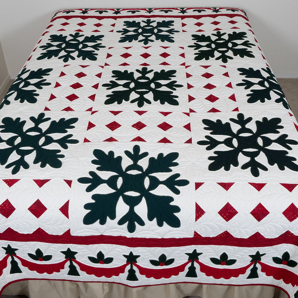 Quilt with black snowflake design on a white background