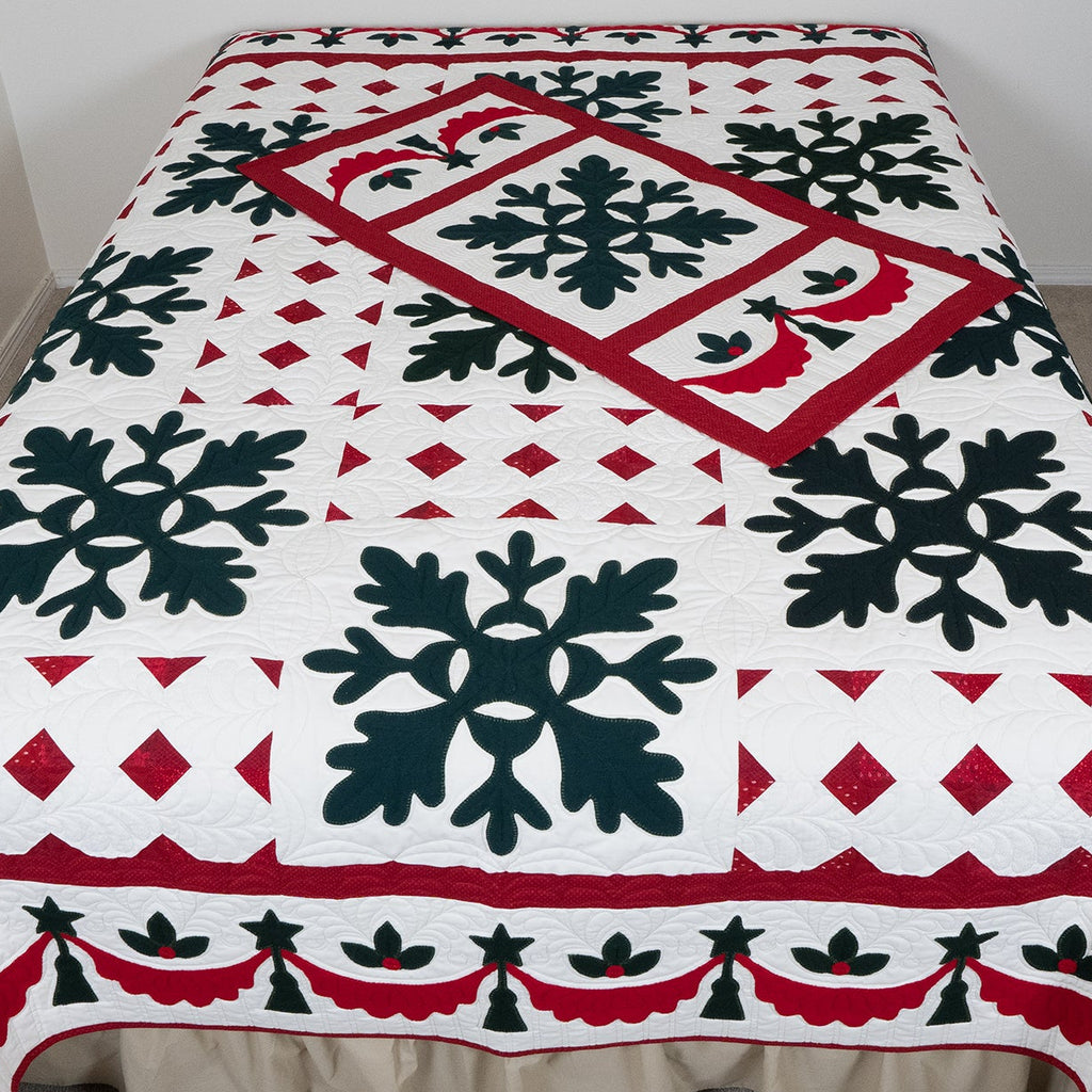 Decorative quilt with snowflake pattern on a bed in a room.