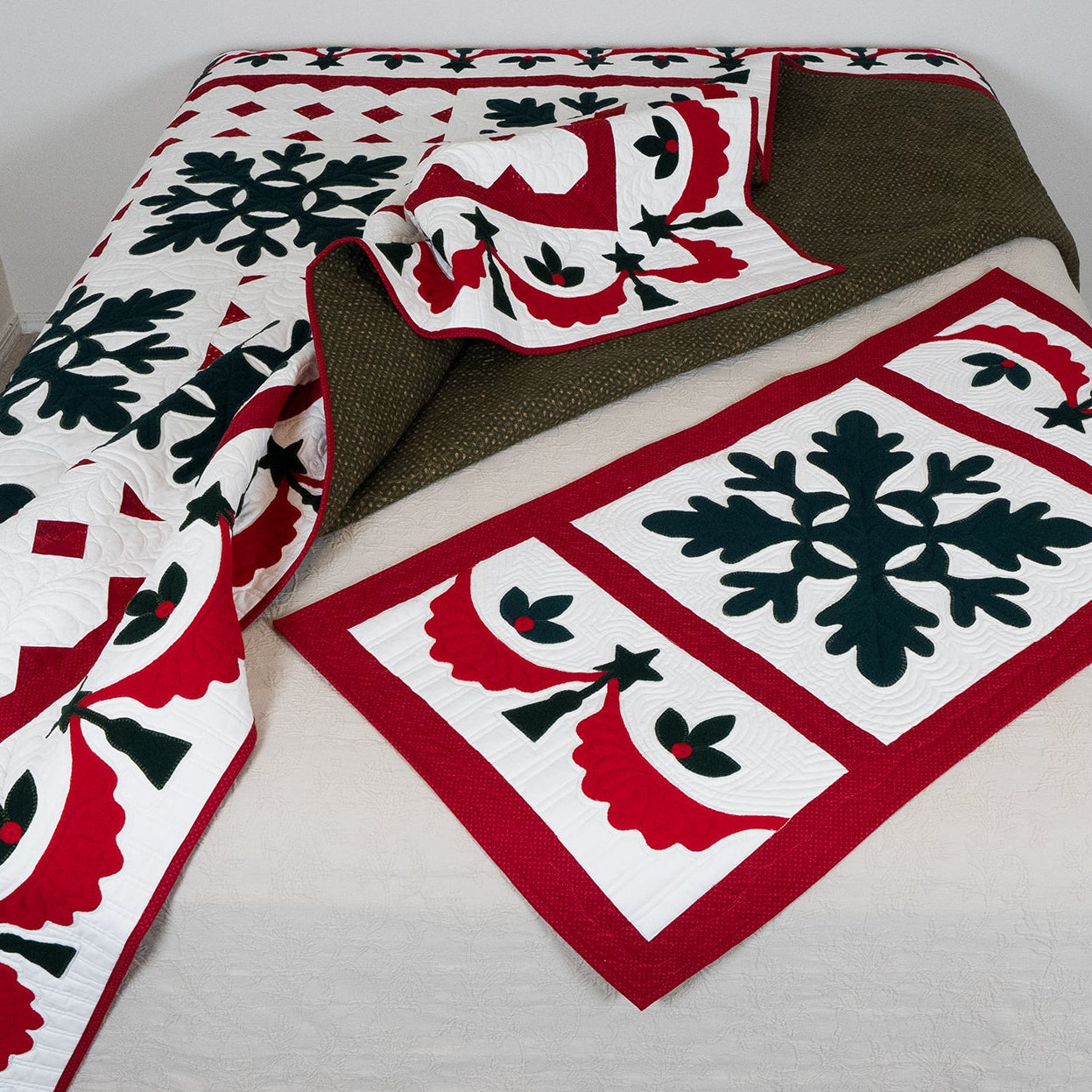 Quilt with festive pattern on a bed against a white wall