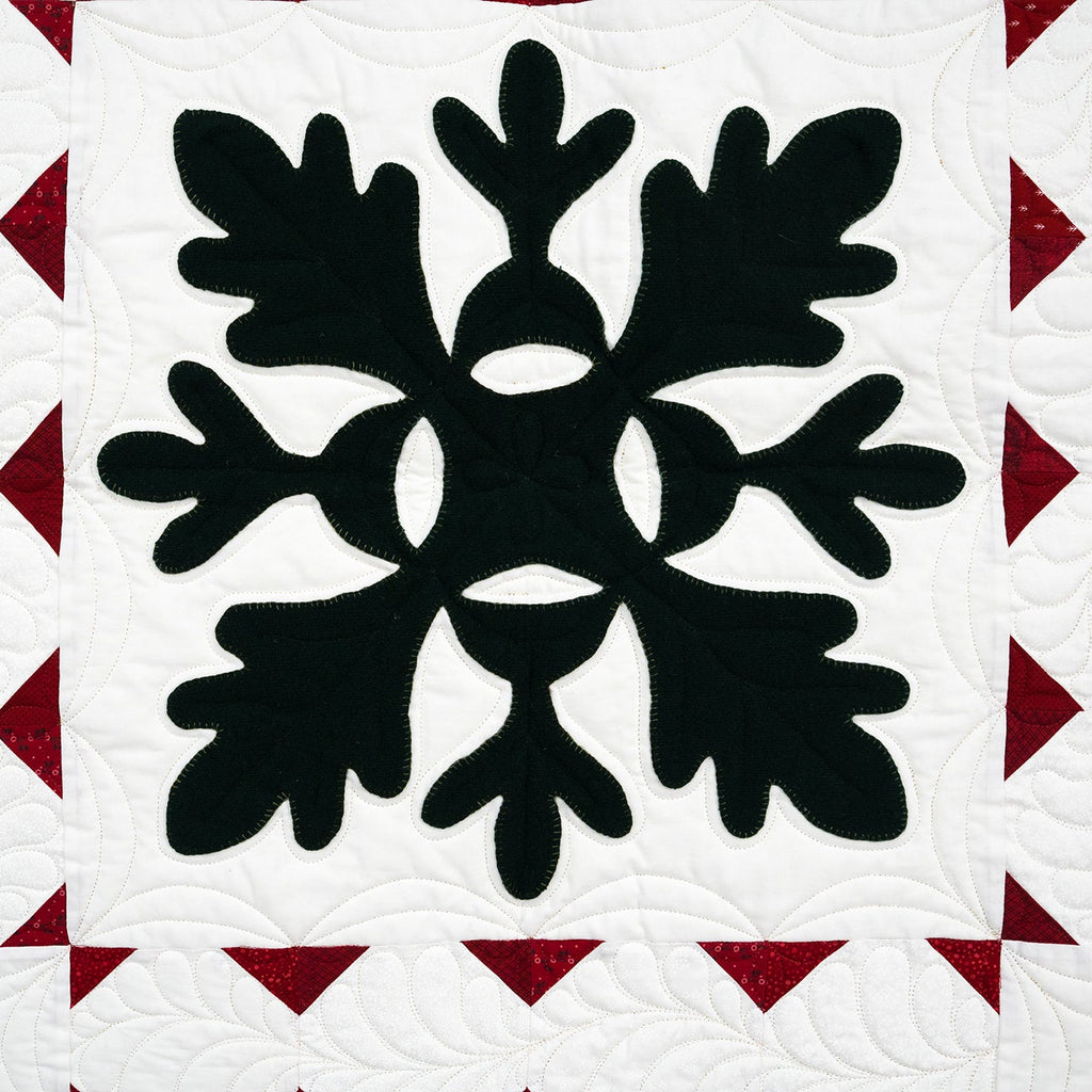 Quilt with black floral pattern on a white background