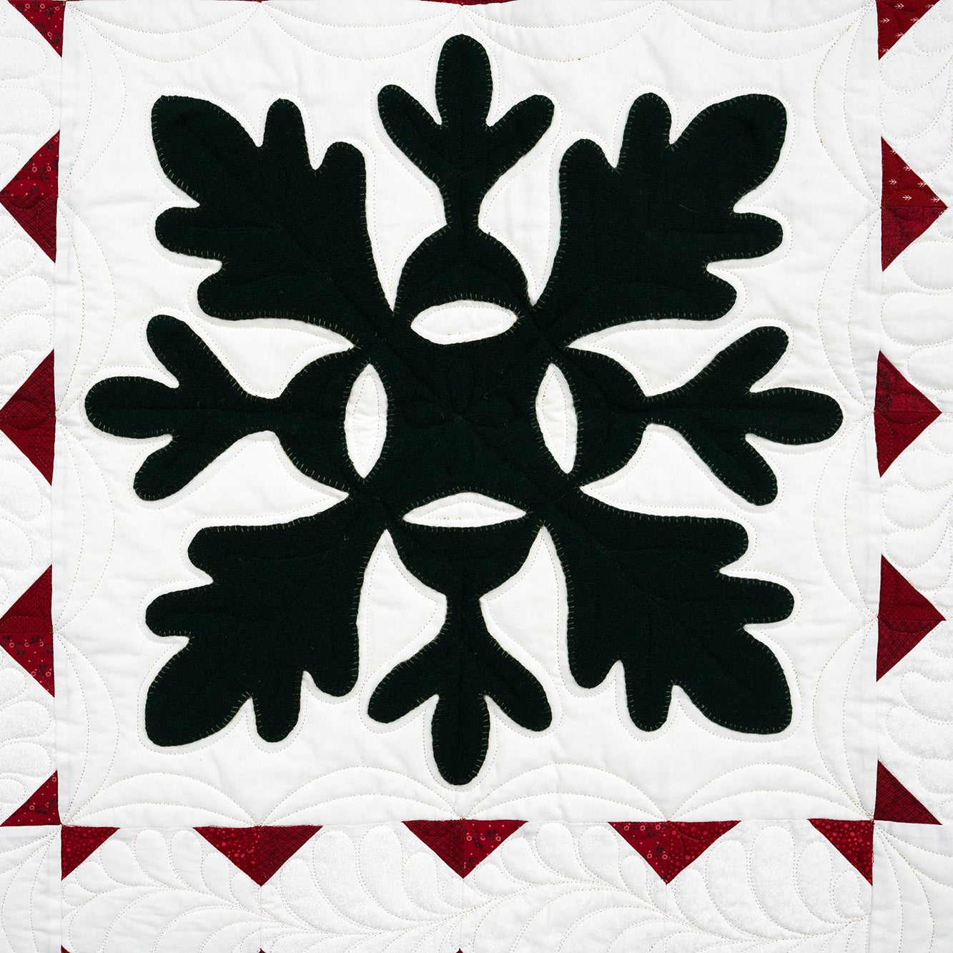 Quilt with black floral pattern on a white background