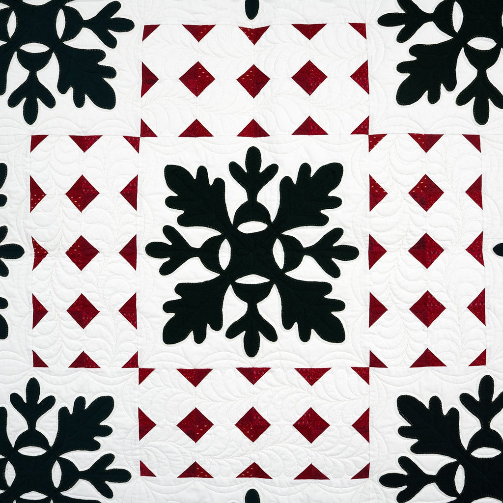 Patterned fabric with black snowflake shapes on a red and white geometric background