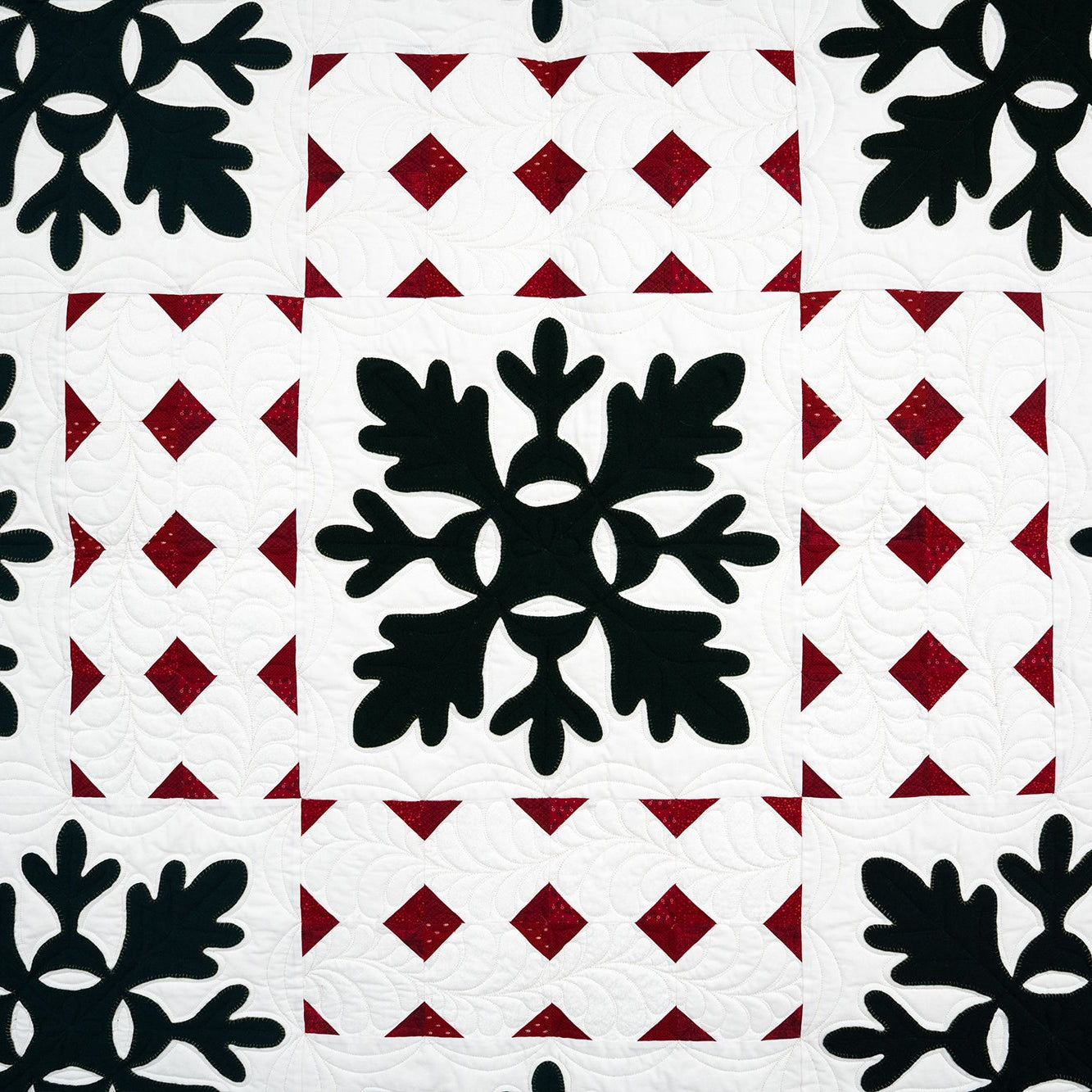 Patterned fabric with black snowflake shapes on a red and white geometric background