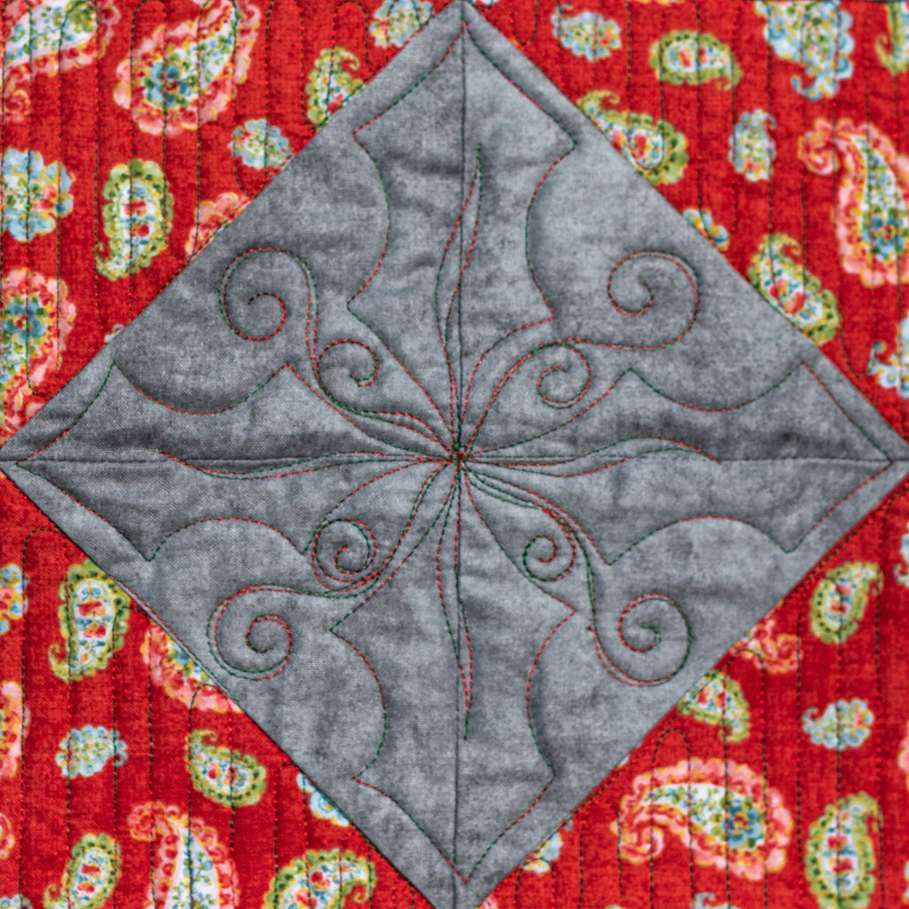 Gray quilted square design on a red paisley patterned fabric