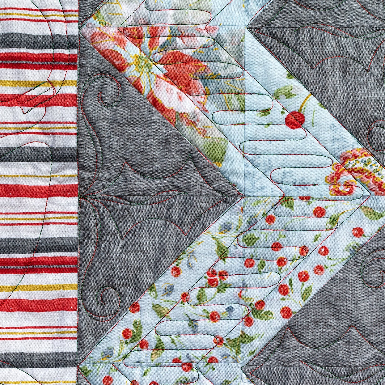 Quilt block with floral and striped patterns on a gray background
