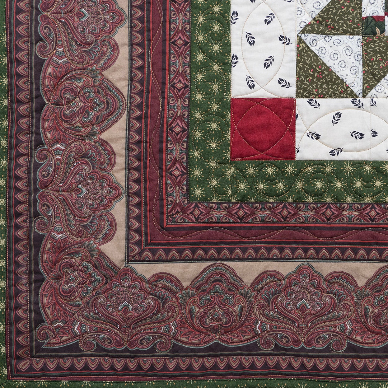 Quilt border made up of an intricate paisley print in deep red