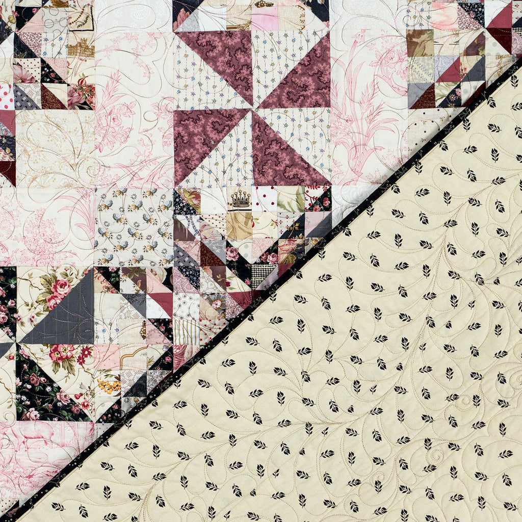 A close-up of a quilted fabric panel with a diagonal split. The top-left section shows a patchwork quilt design with floral and geometric blocks in cream, burgundy, black, and beige.