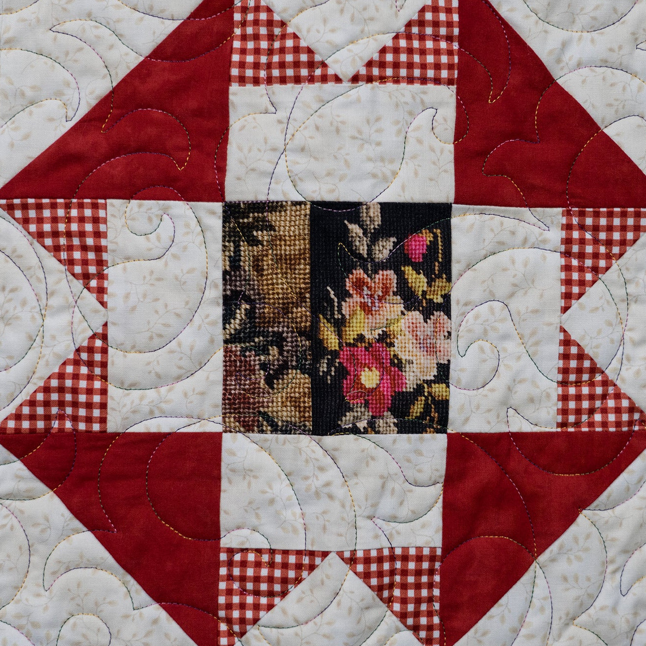 Quilt with patchwork design featuring various patterns and colors.