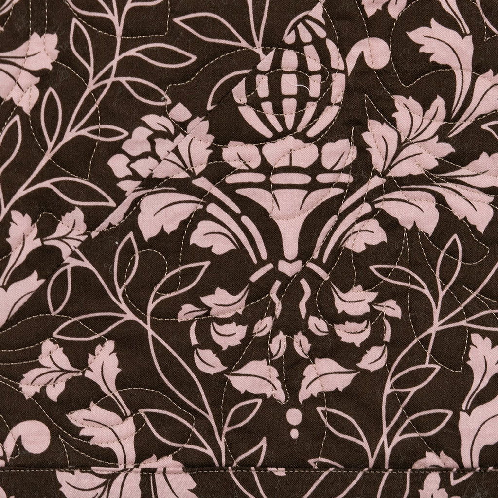 A close-up of a fabric pattern featuring a dark brown background with a light pink damask floral and acanthus leaf design.