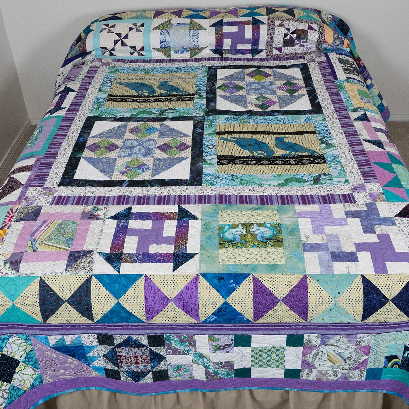 Colorful patchwork quilt on a bed against a plain wall.