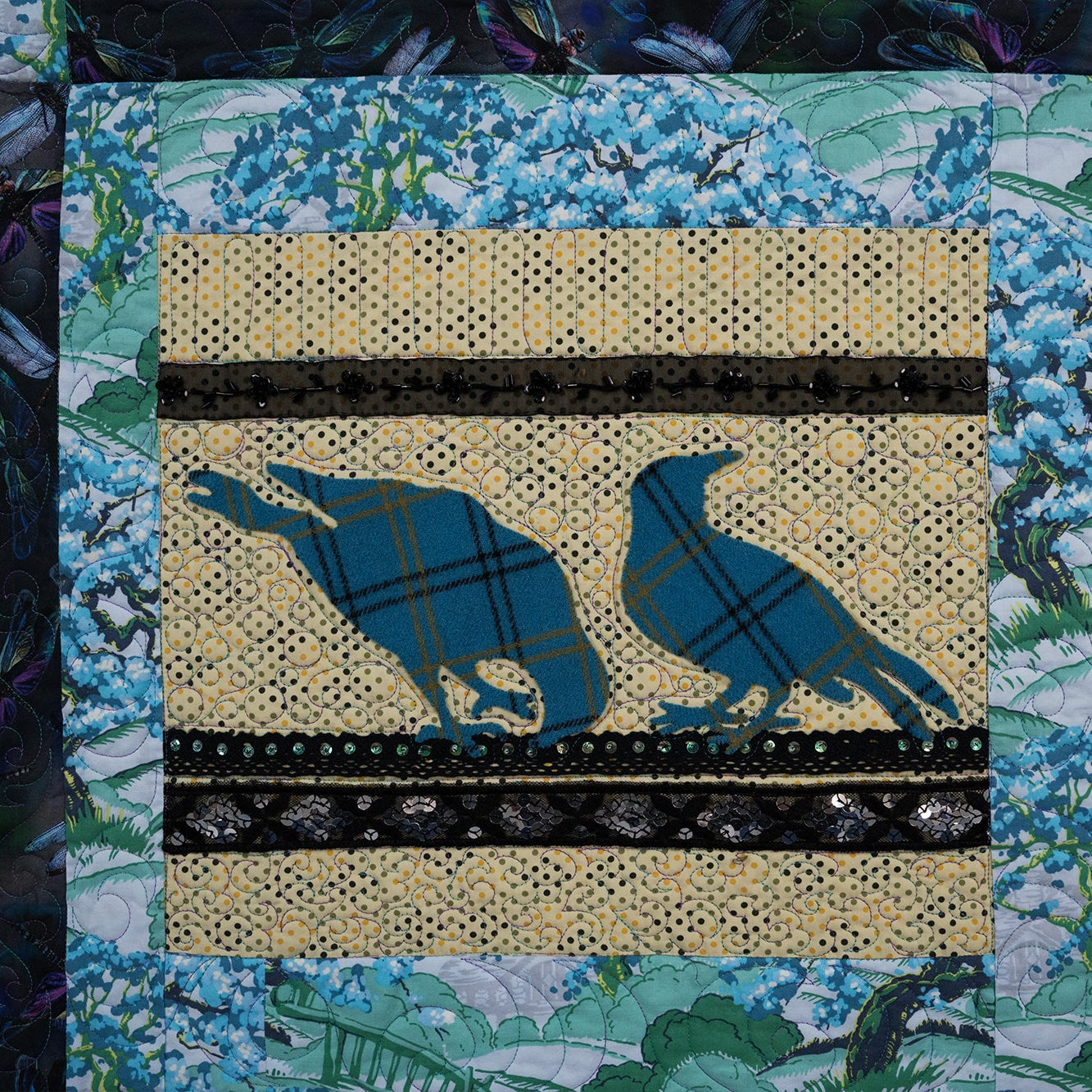 Quilt block with blue bird design on a multicolored fabric background