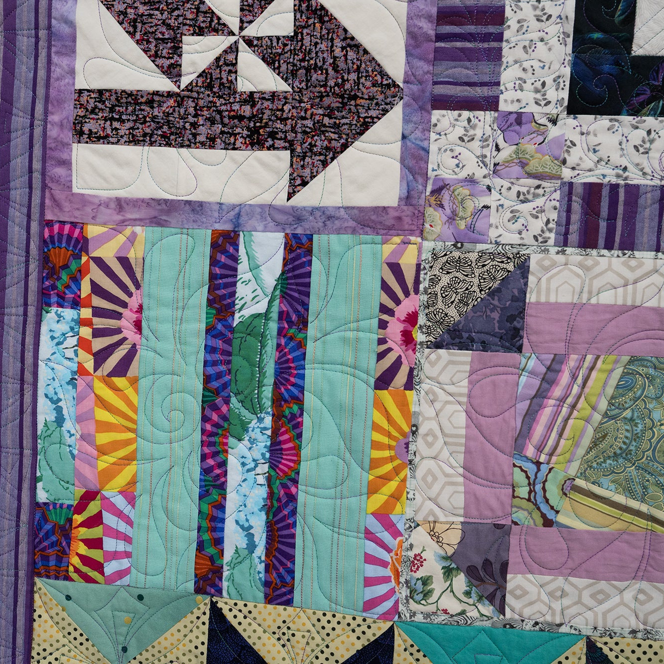 Colorful patchwork quilt with various patterns and colors.