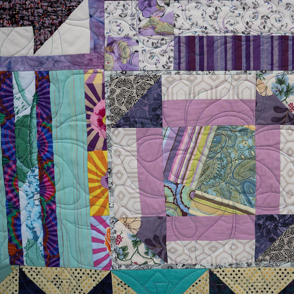 Quilt with various patterns and colors, featuring a mix of textures and designs.