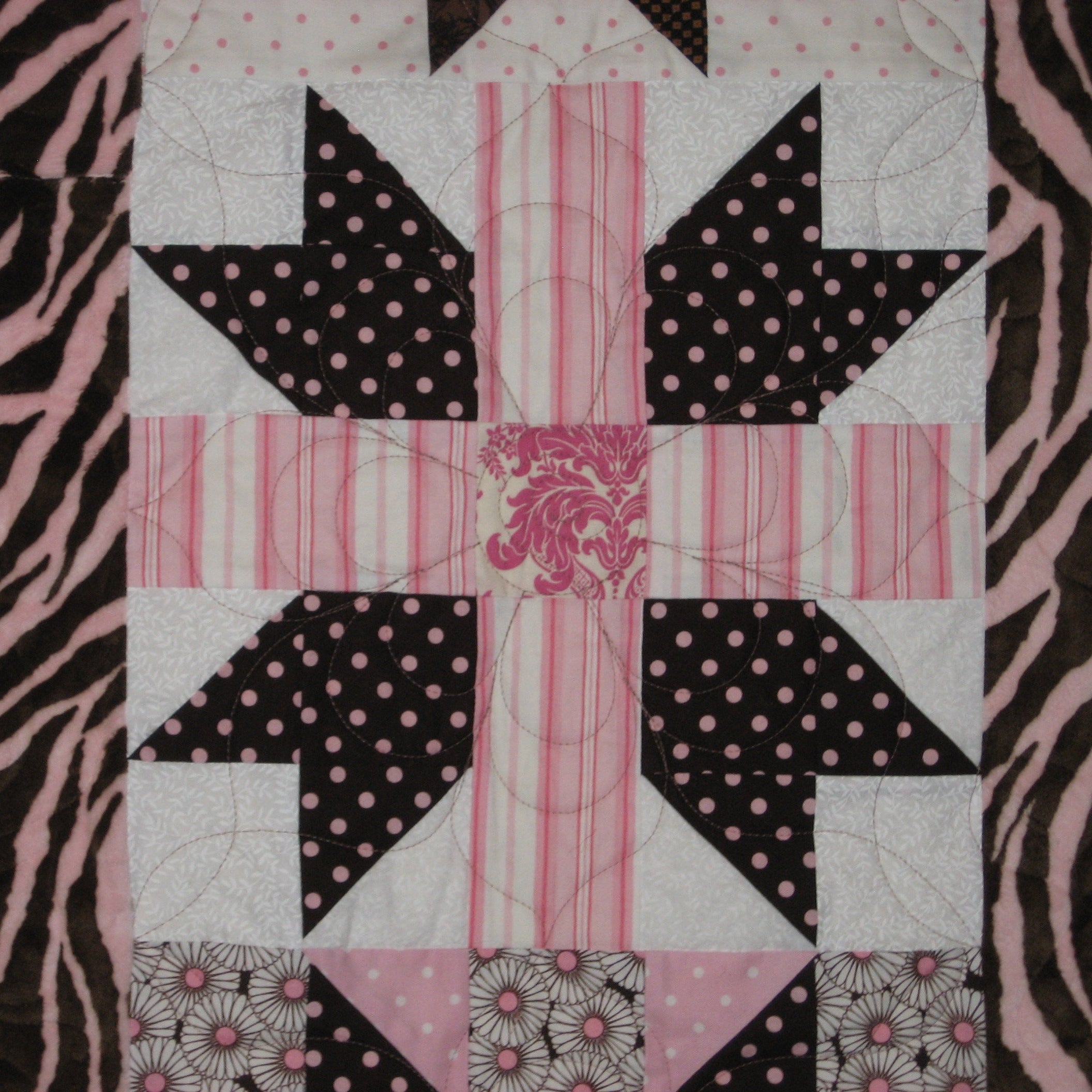 Quilt block in pink and brown with a variety of prints including strips, polkadot and animal print