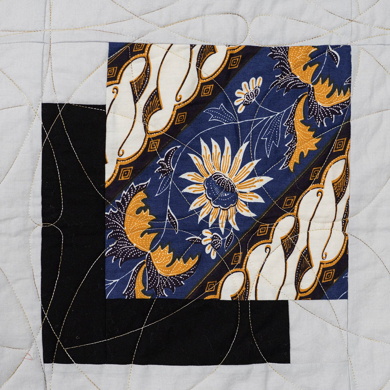 Quilt block with floral and abstract patterns on a white background