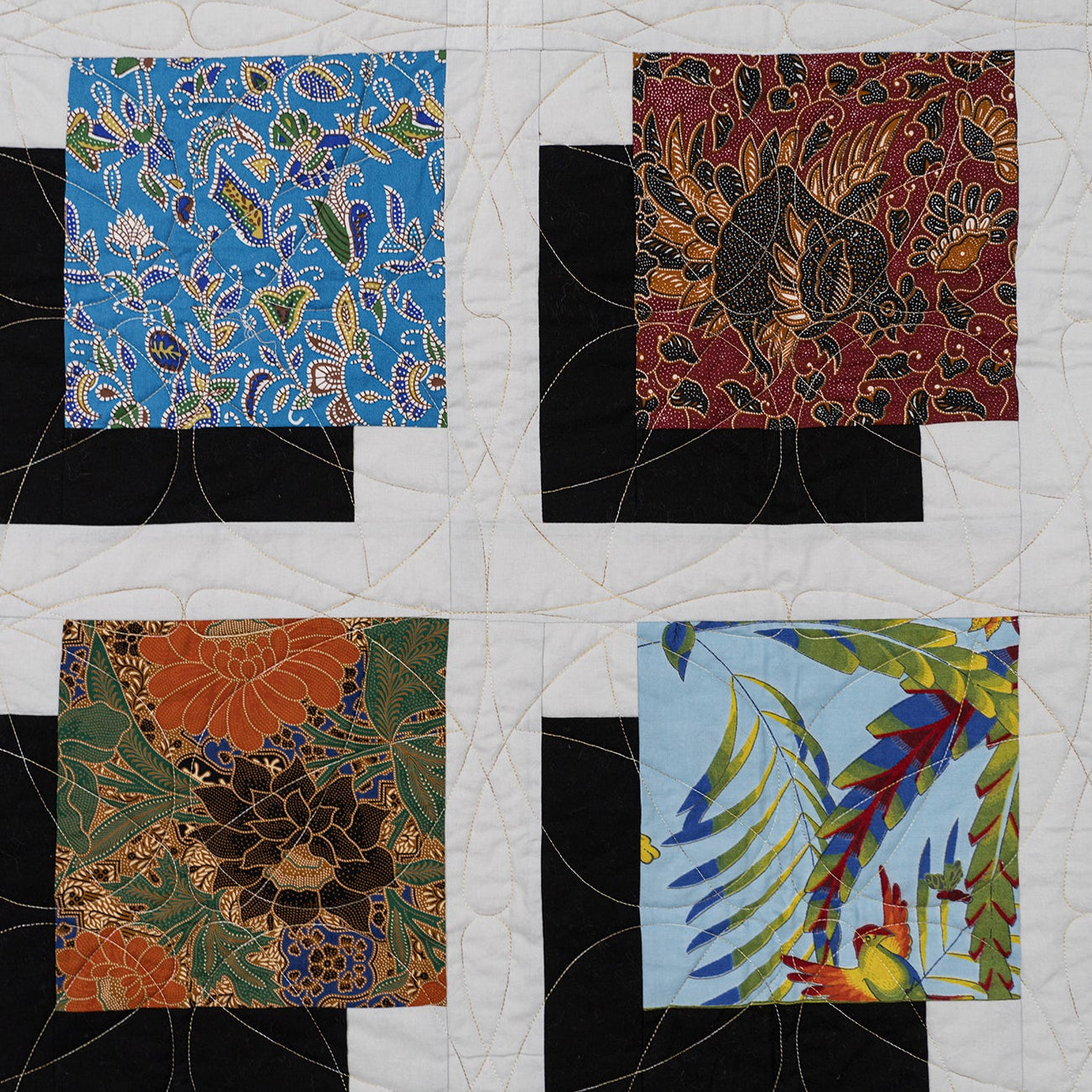 Quilt with various patterned fabric squares on a white background