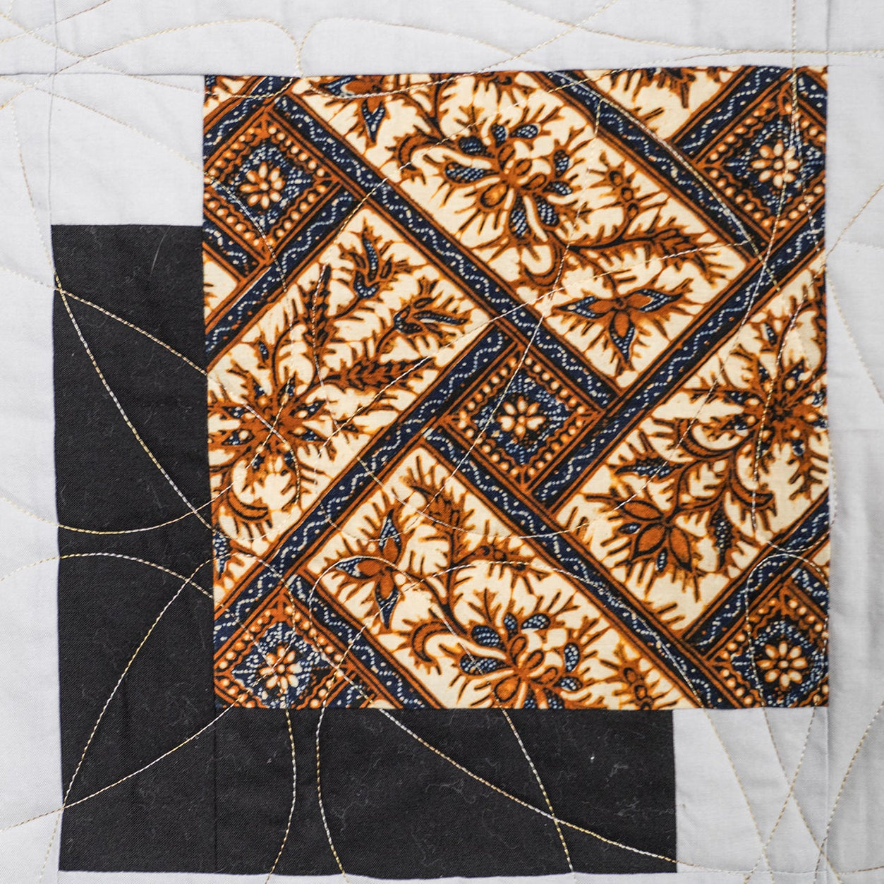 Quilt with geometric patterned square in center