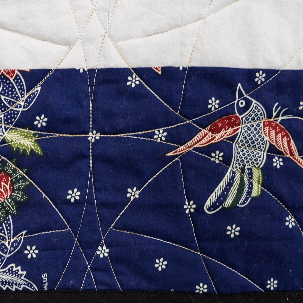 Embroidered fabric with a bird design on a blue background