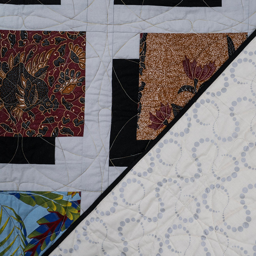 Quilt with various patterns including floral, geometric, and abstract designs.