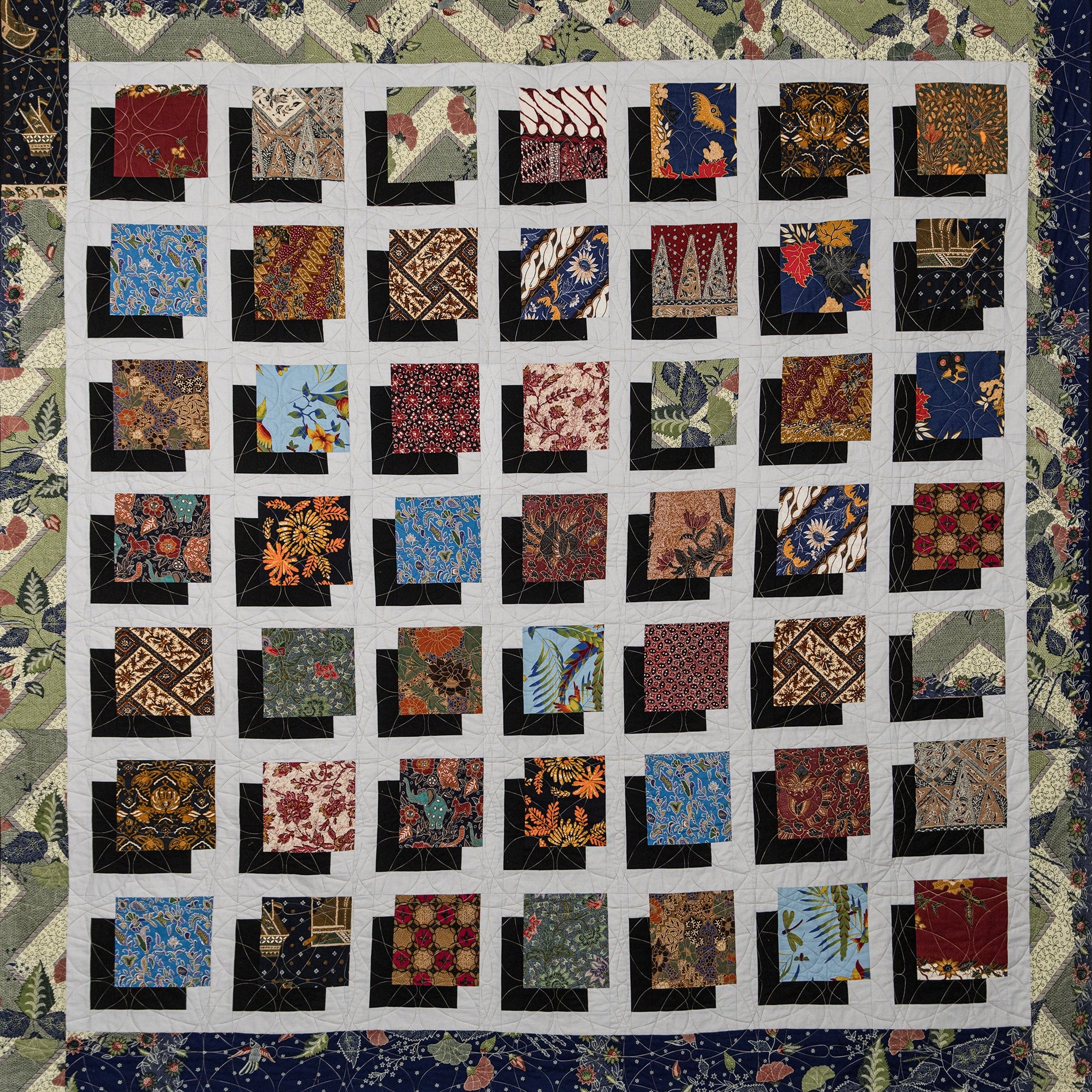 Quilt with a patchwork design featuring various patterns and colors.