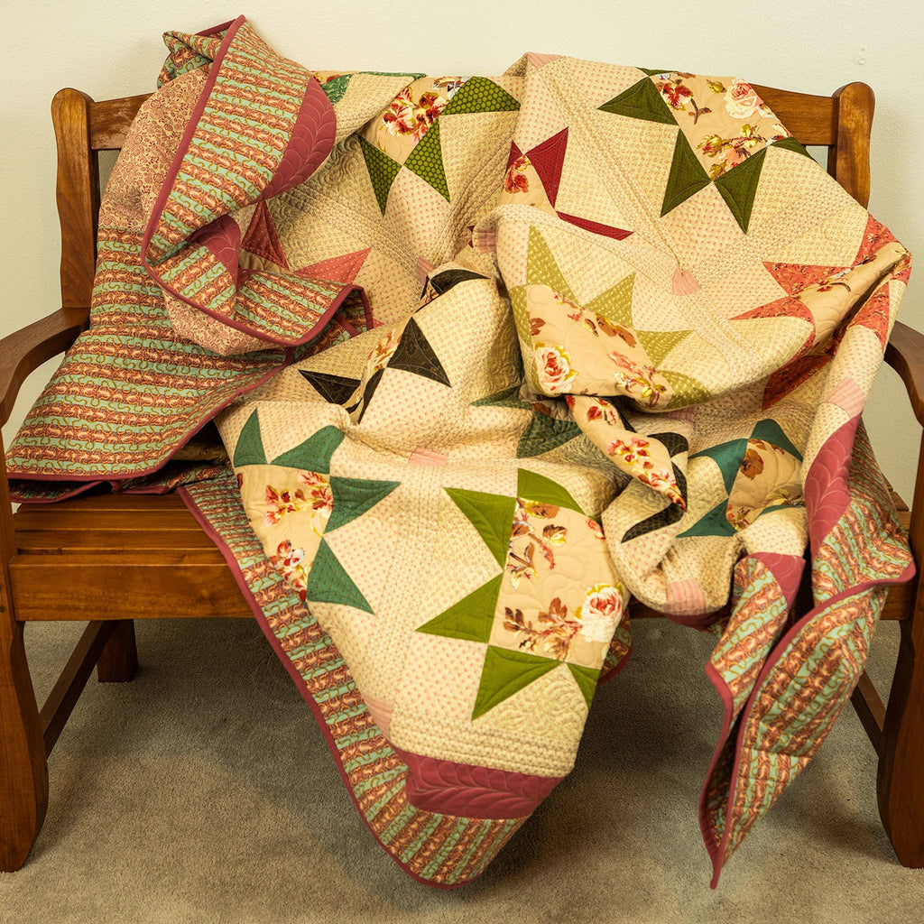 A multicolor patchwork quilt with geometric star patterns and floral prints draped over a wooden armchair in an indoor setting.