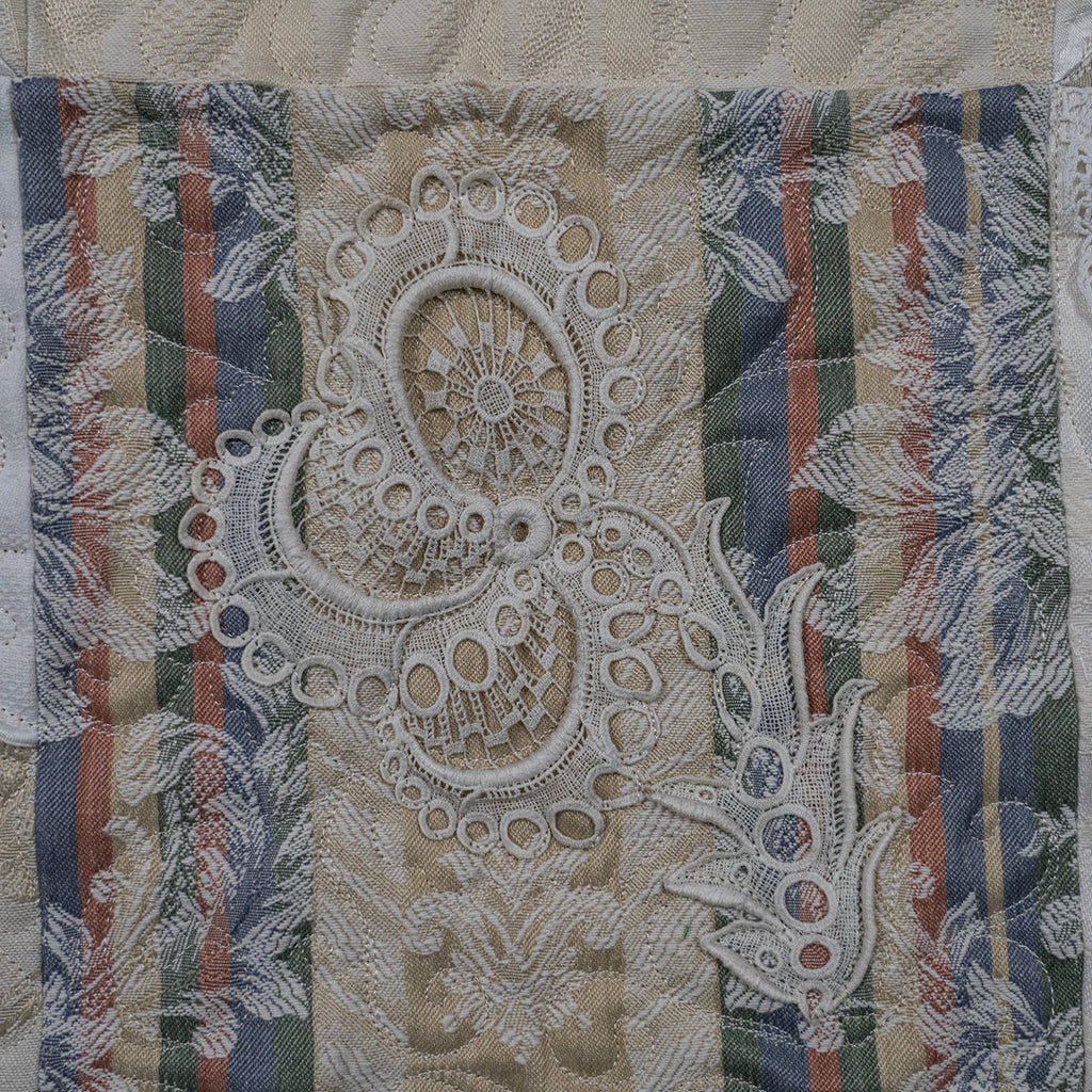 Decorative fabric with lace and striped patterns on a textured background