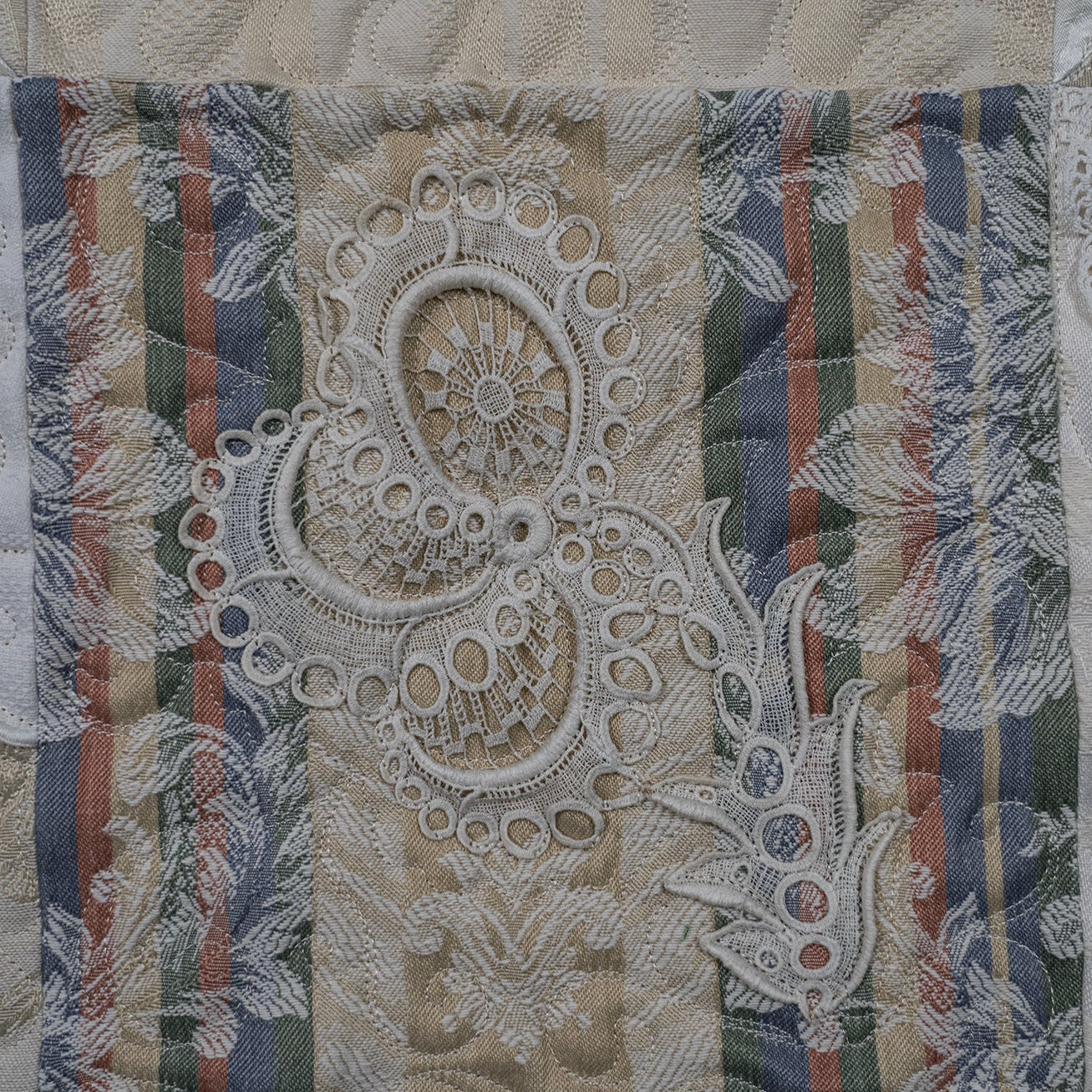 Decorative fabric with lace and striped patterns on a textured background