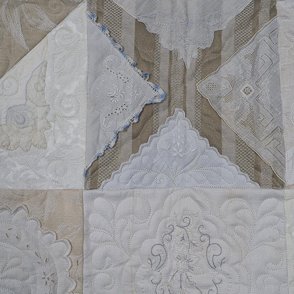 Quilt with intricate patterns in beige and white