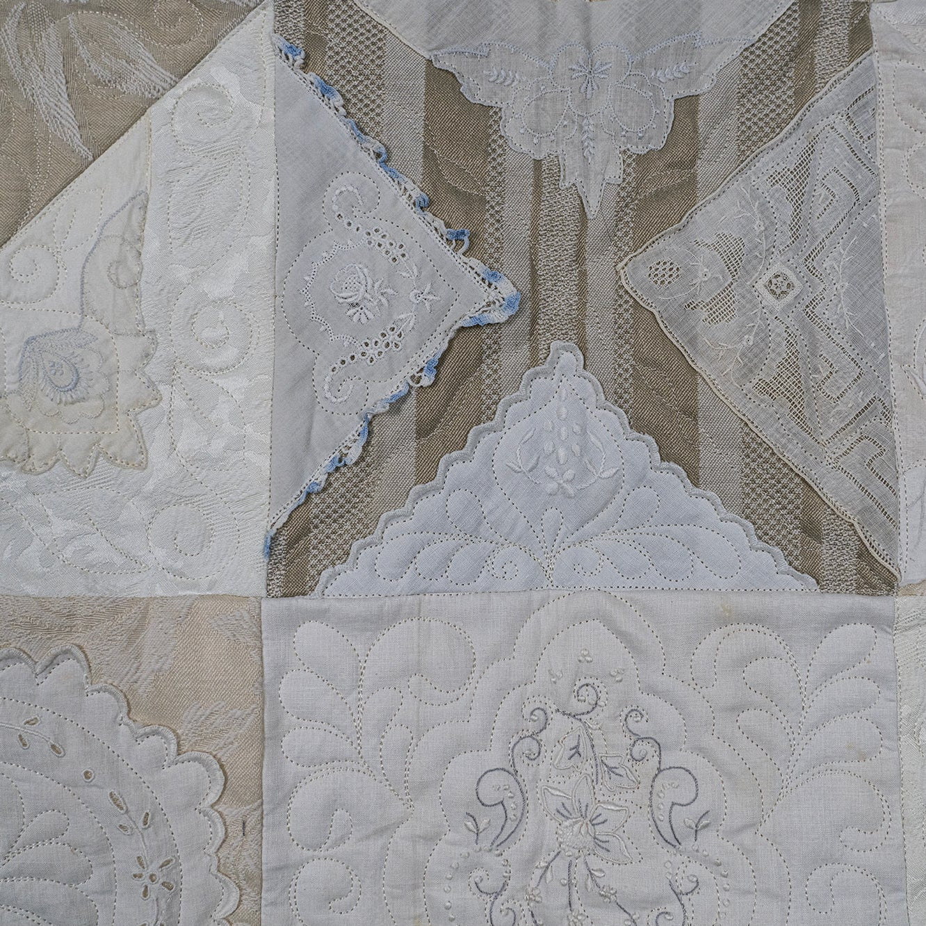 Quilt with intricate patterns in beige and white