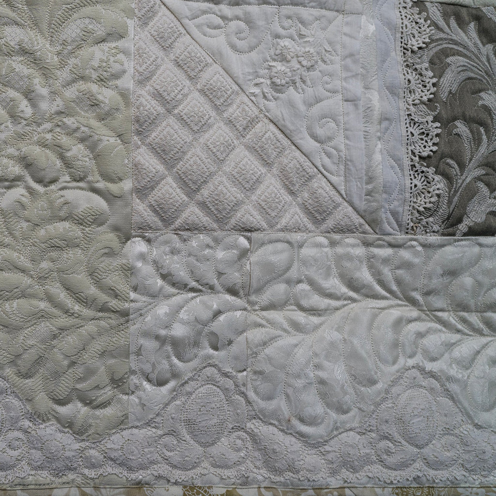 Textured quilt with various patterns and designs.