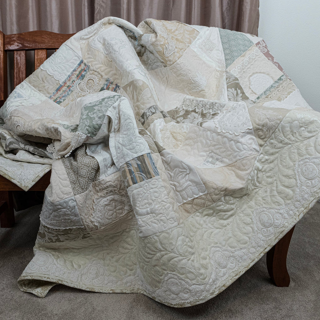 Quilt draped over a wooden chair in a room with neutral decor