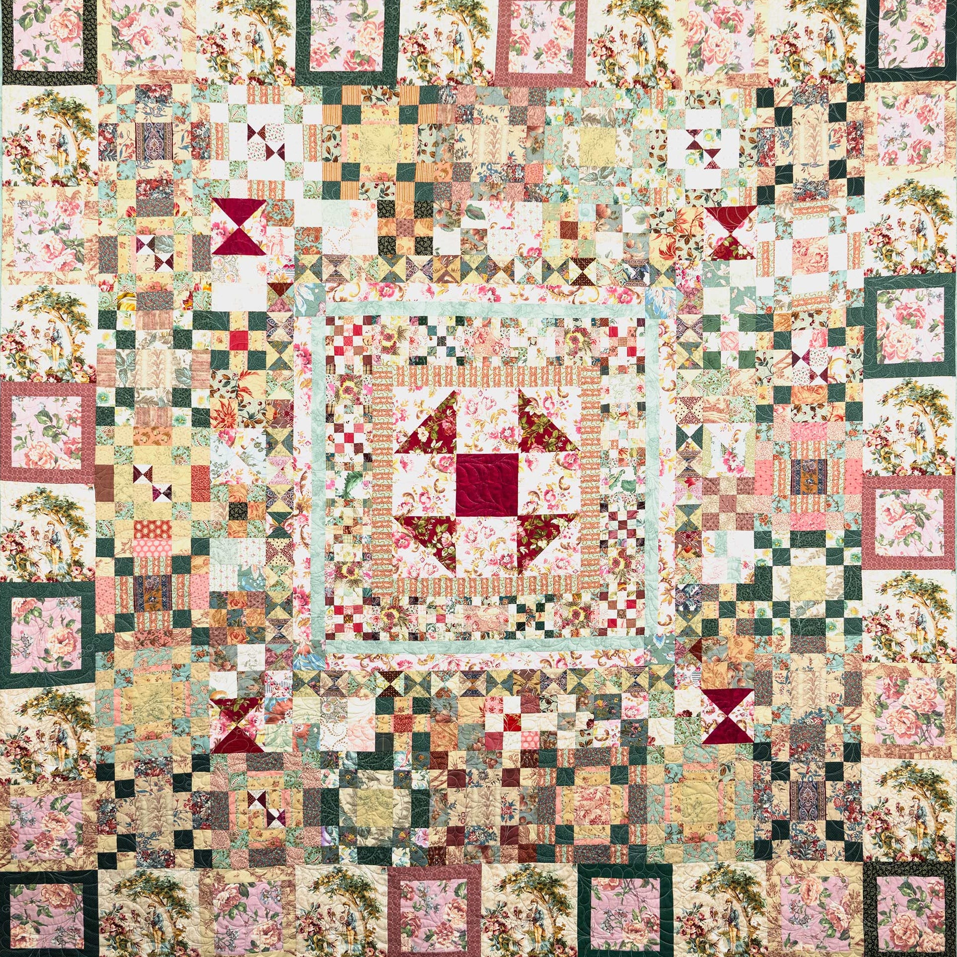 A square vintage-style quilt with a complex patchwork design featuring floral prints, checkered squares, and geometric blocks in muted pink, green, beige, and burgundy tones.