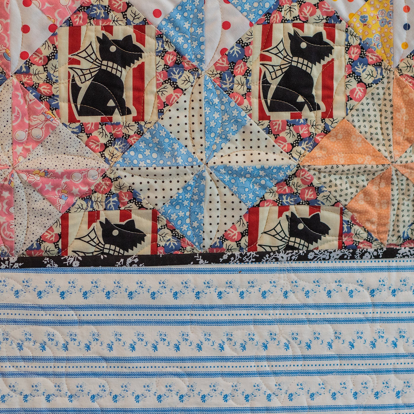 Quilt with star pattern featuring black dog designs on a colorful background