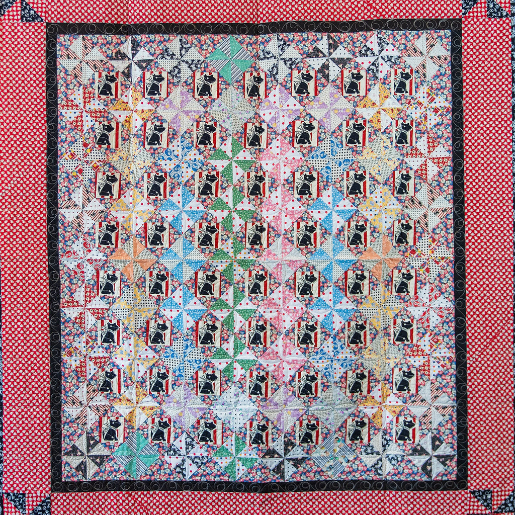 Quilt with a geometric pattern in a red border