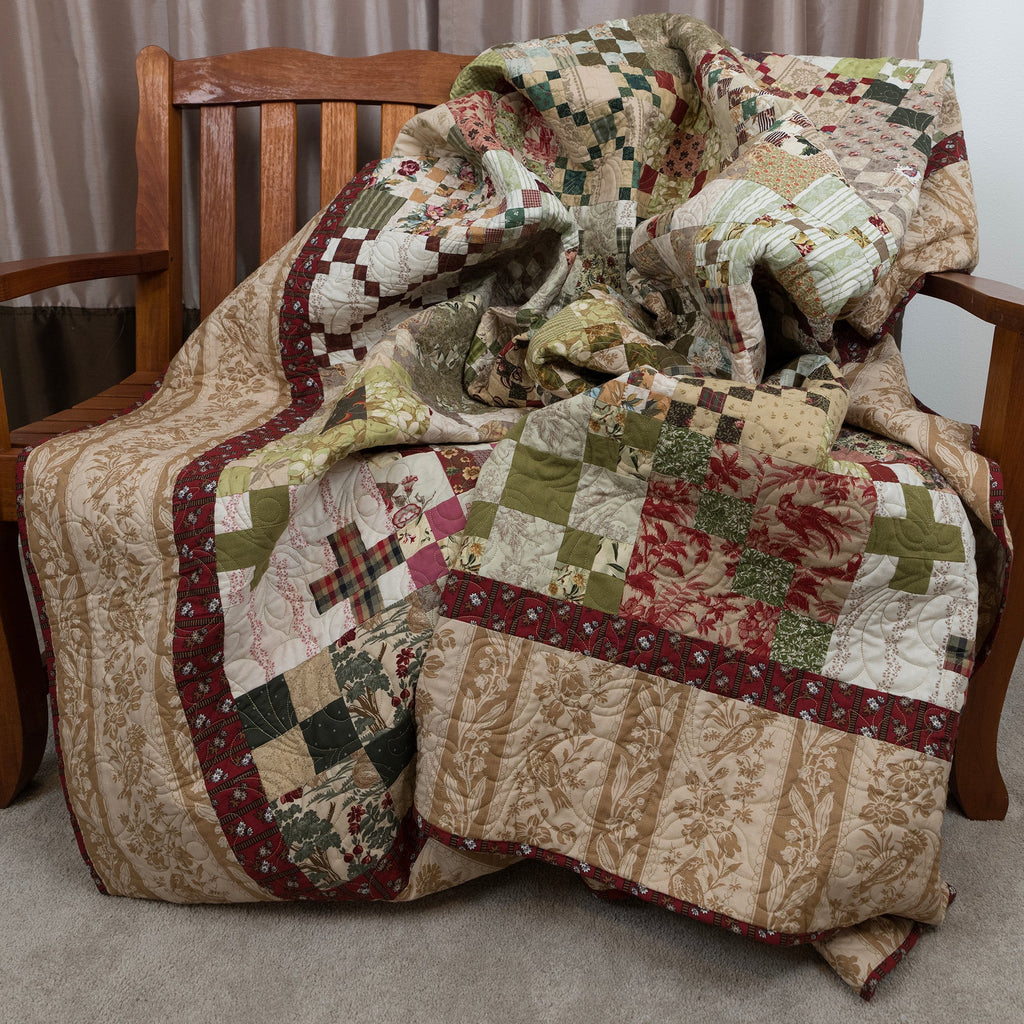 Patchwork quilt draped over a wooden chair with a neutral background