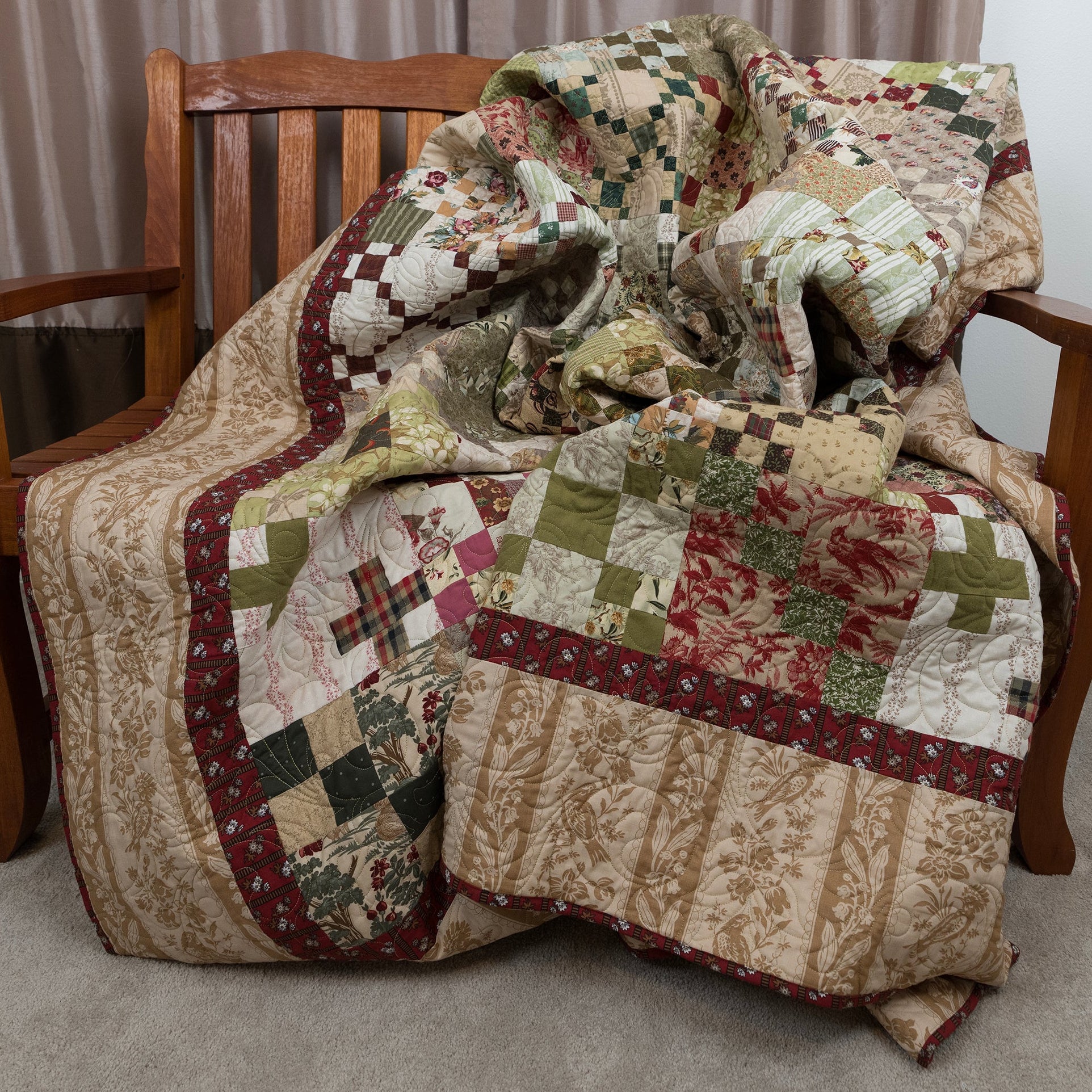 Patchwork quilt draped over a wooden chair with a neutral background