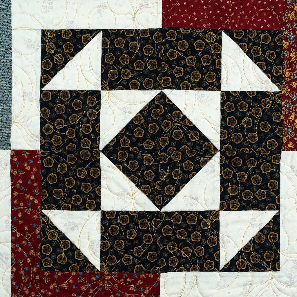 Quilt with geometric pattern featuring brown, white, and red colors