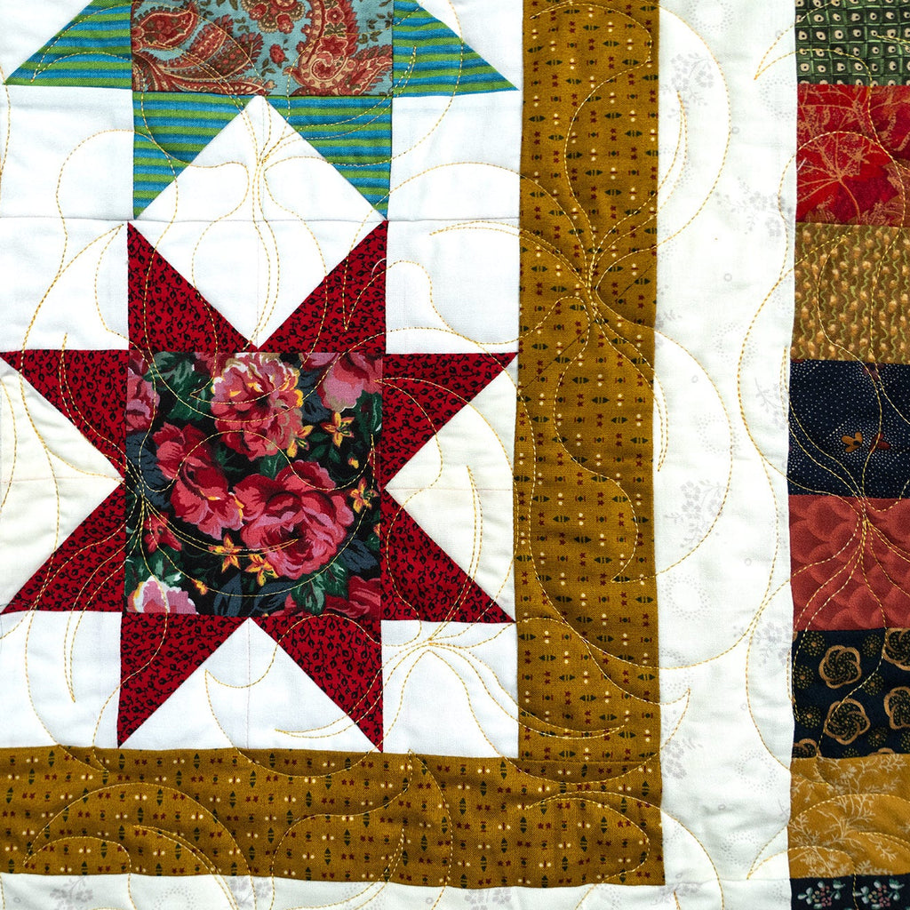 Quilt with floral star design and various patterns