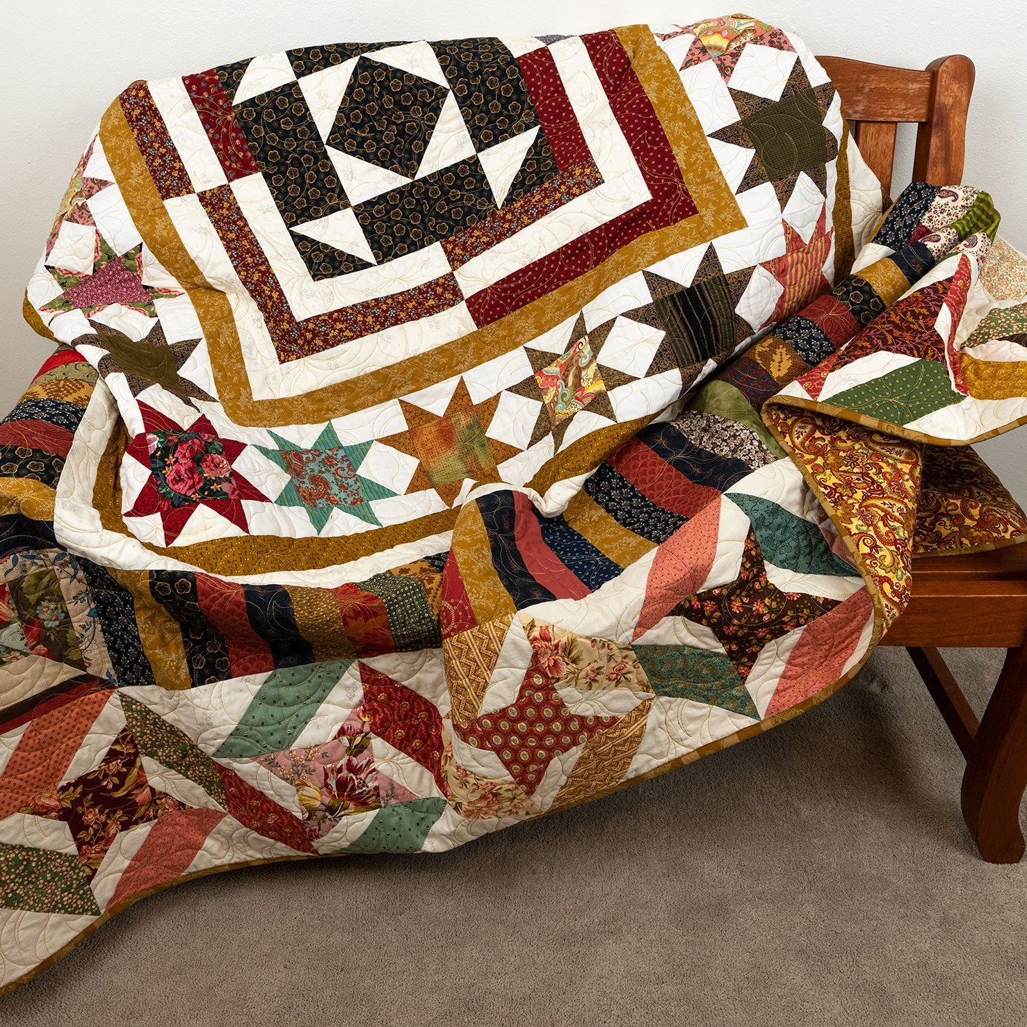 Colorful patchwork quilt draped over a wooden chair against a neutral background