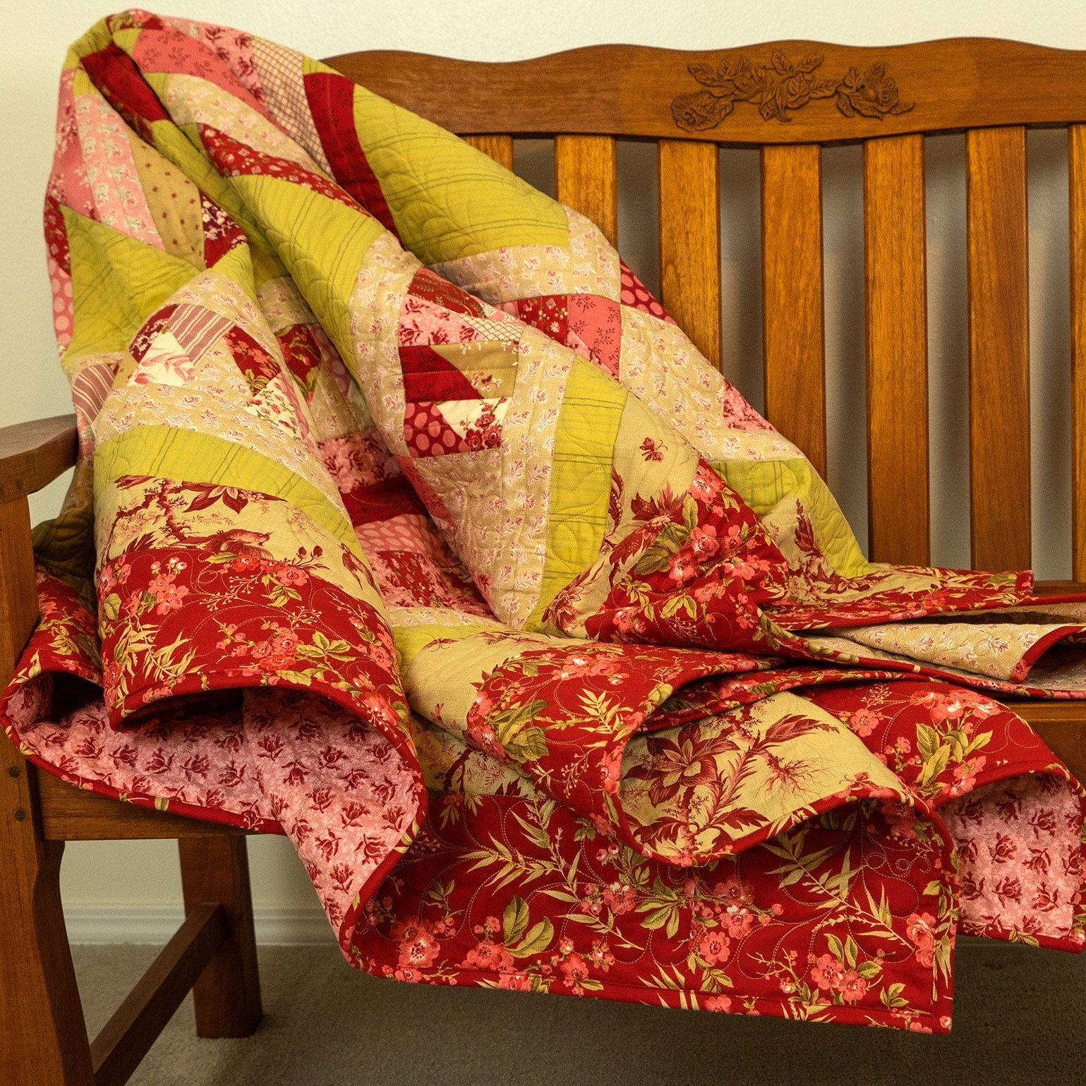 Colorful patchwork quilt draped over a wooden bench.