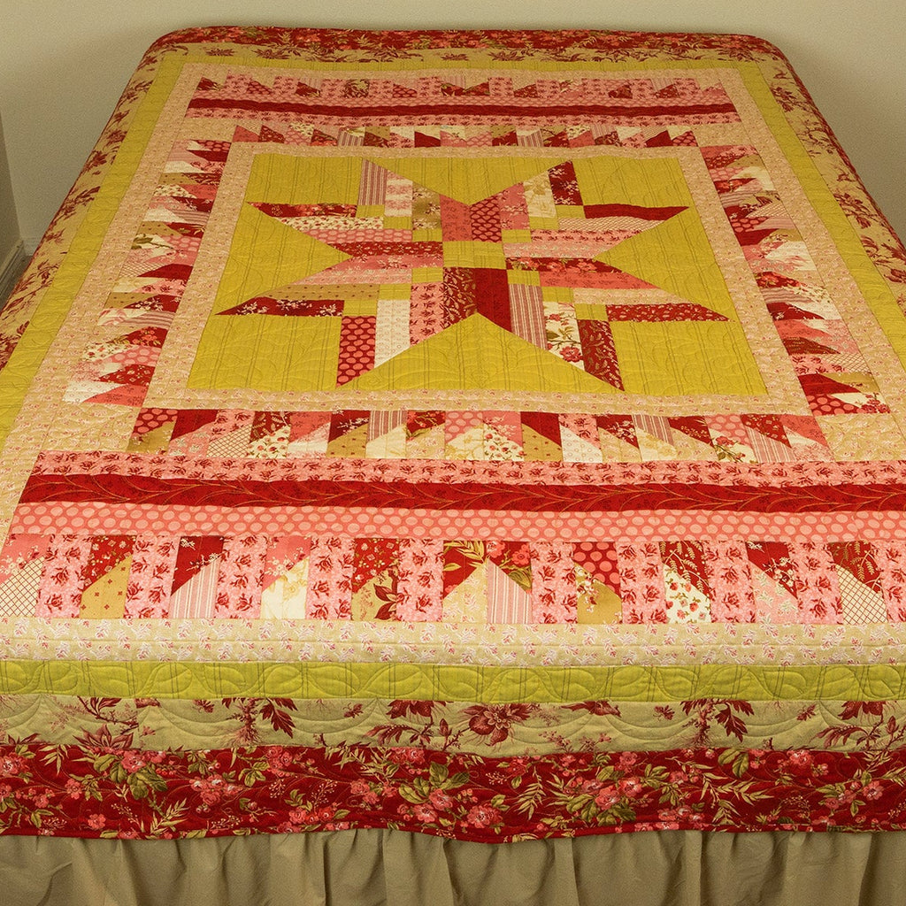 Quilt with star pattern on a bed against a plain wall