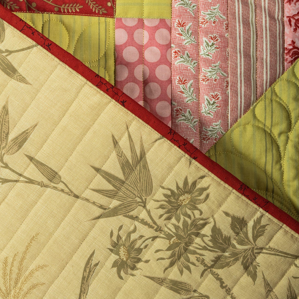 Quilt with bamboo pattern and colorful fabric squares in the corner