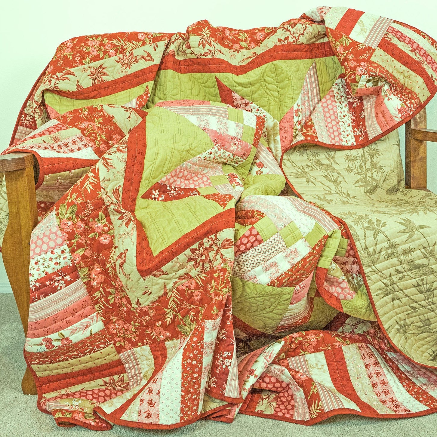 Colorful quilt draped over a wooden chair against a light wall.