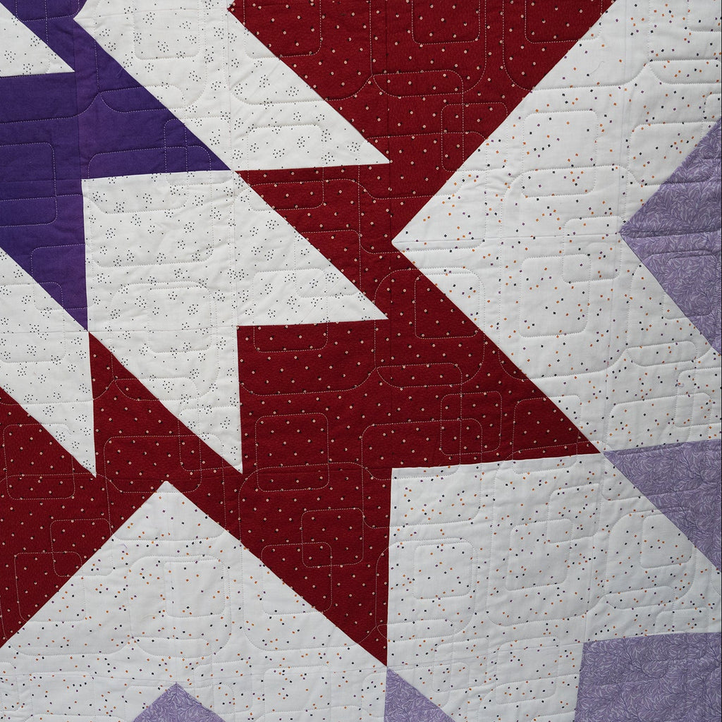 Quilt with geometric pattern in red, white, and blue