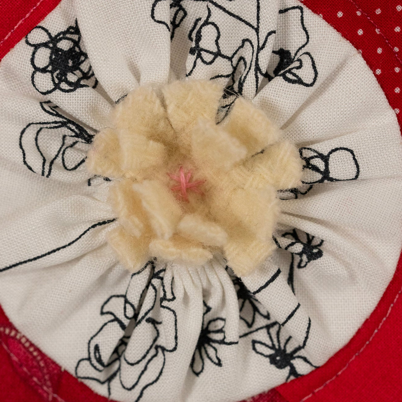 Floral fabric scrunchie with embroidered flowers on a red background