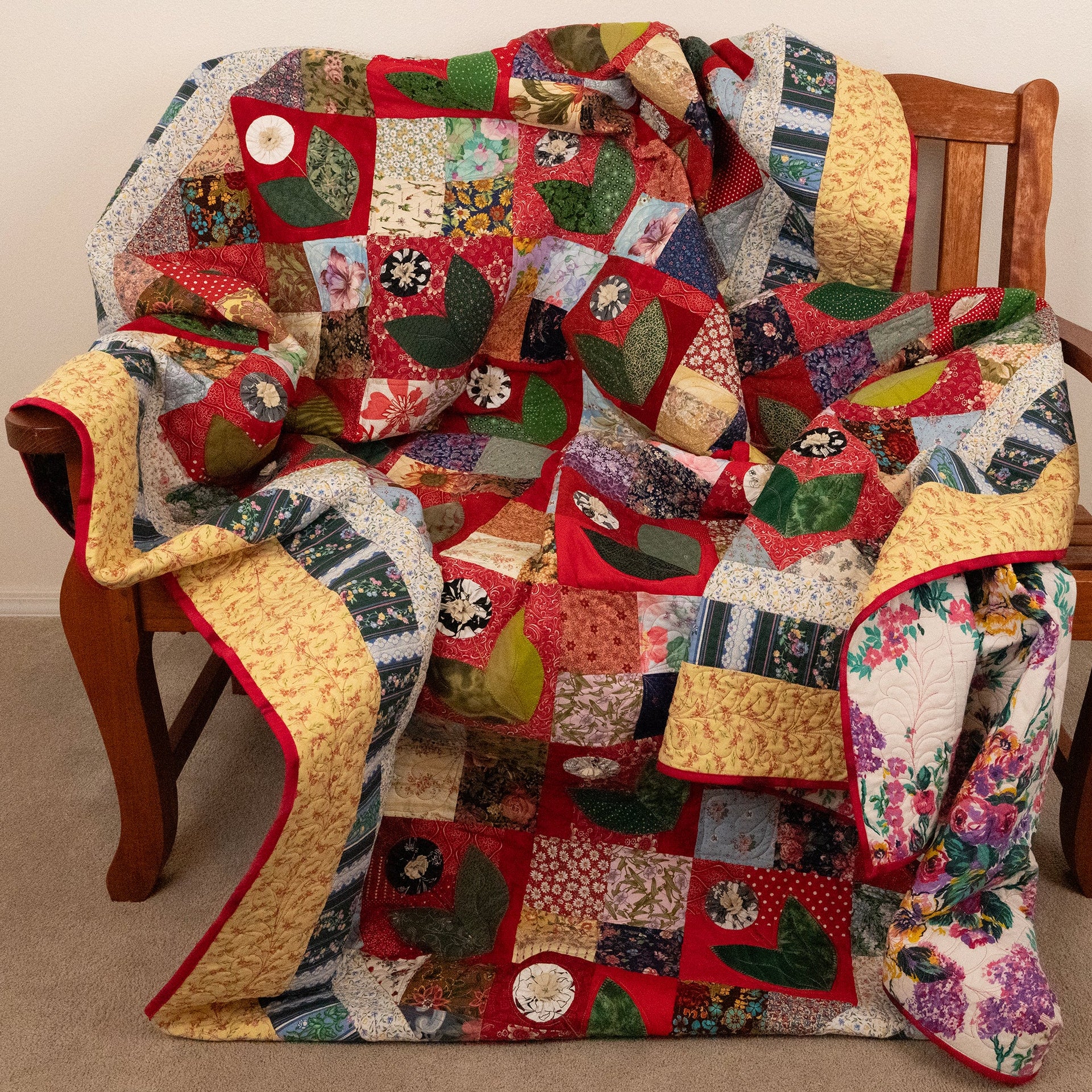 Colorful patchwork quilt draped over a wooden chair.
