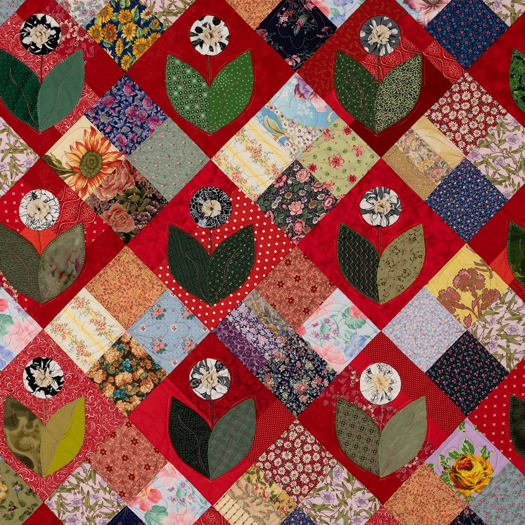 Quilt with floral and leaf patterns on a red background