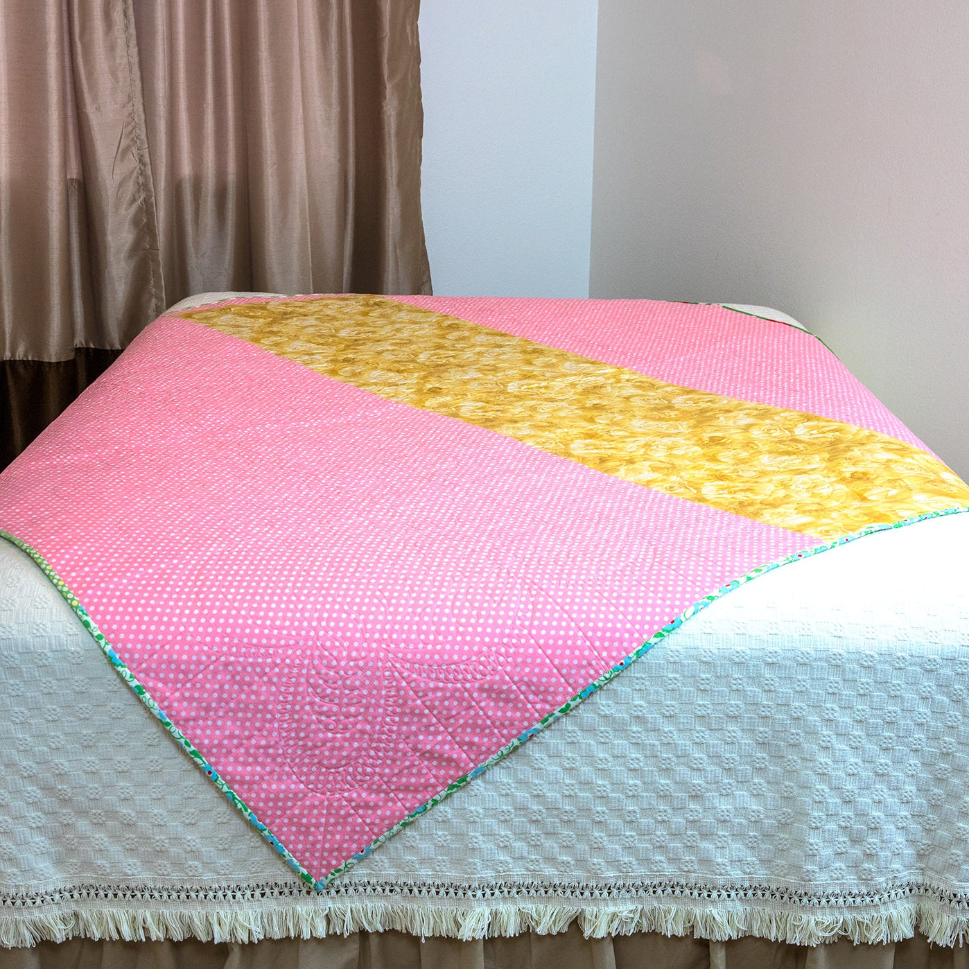 Colorful quilt on a bed with a neutral background
